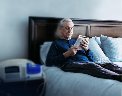 Man sitting in bed and reading while receiving APD