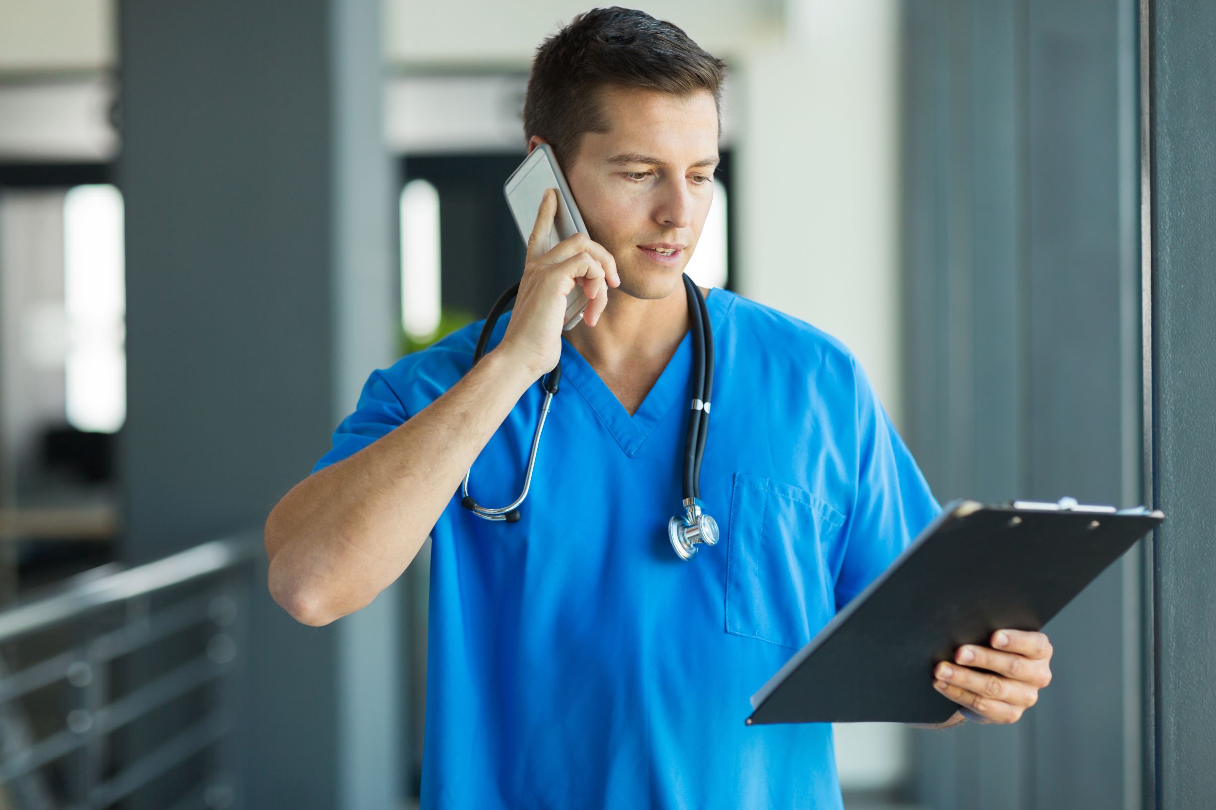 Doctor on phone holding tablet
