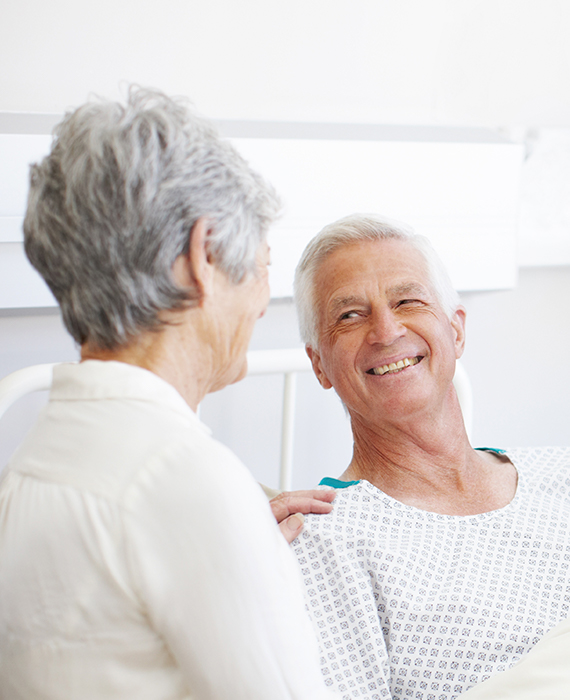 Man in hospital robe smiling