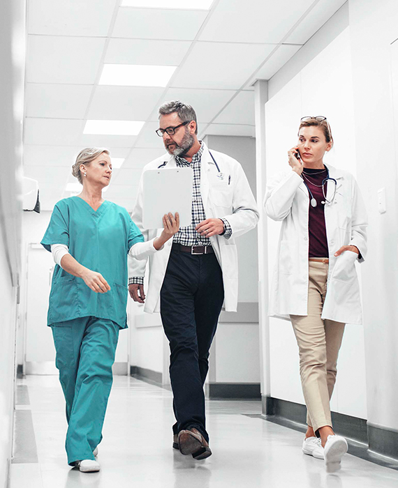 Doctors walking down a hallway discussing a patient chart