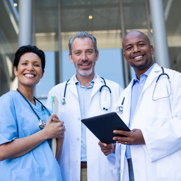 Three doctors standing together smiling