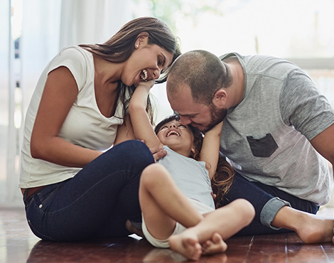 A young couple smiling and laughing with a small child