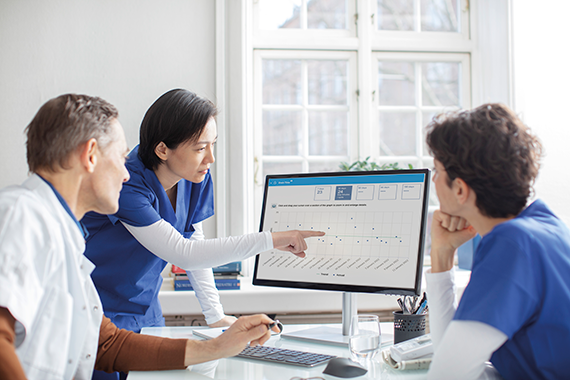 A group of specialists discussing data analytics presented on a computer screen